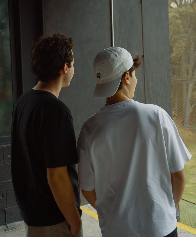 Dos amigos de espaldas mirando el campo de golf
