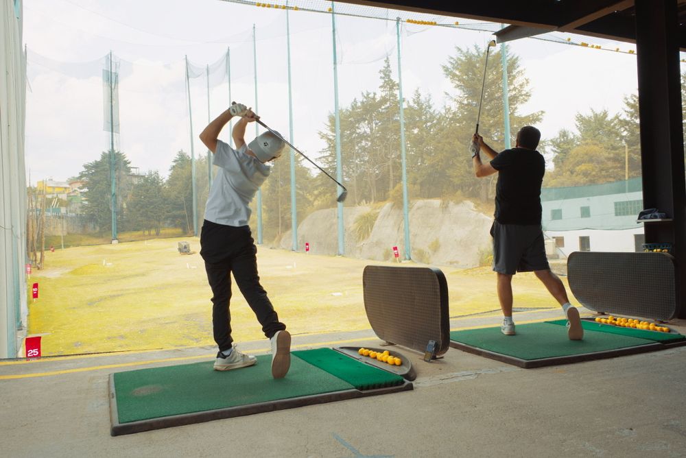 Dos golfistas practicando en el driving range