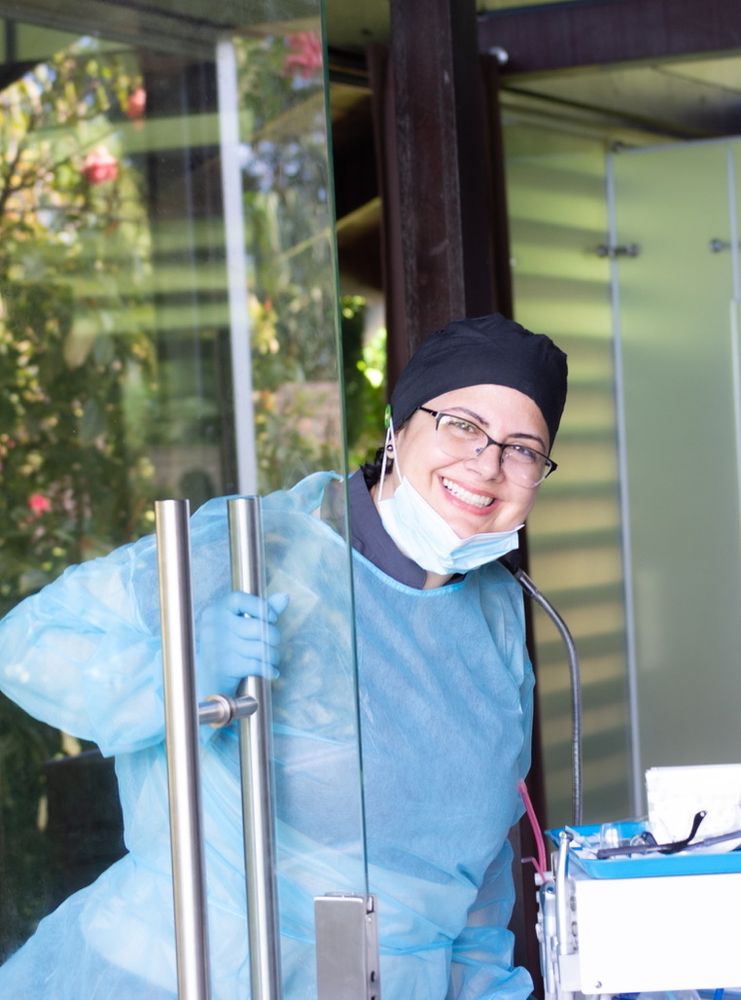 Odontóloga sonriendo en la puerta de su consultorio